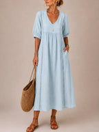 Woman accessorizing the versatile midi dress with a simple necklace and sandals for an effortlessly chic look.