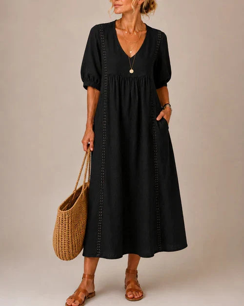 Close-up detail of the delicate lace trim adorning the V-neckline of the flowing summer midi dress.