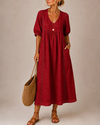 Rear view of the stylish midi dress, showcasing its relaxed fit and graceful movement as a woman walks.