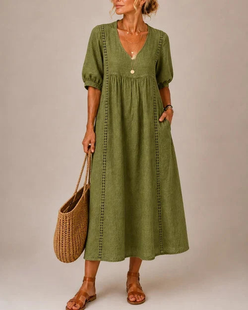 Side profile of the elegant midi dress, highlighting its fluid drape and comfortable three-quarter sleeves.